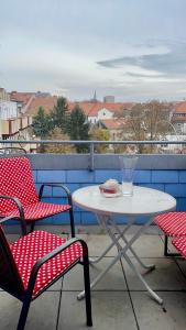 einen Tisch und zwei Stühle und ein Glas auf dem Balkon in der Unterkunft Grazer Schwalbe in Graz