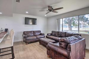 a living room with leather furniture and a ceiling fan at Central Bakersfield Townhome with Private Patio in Bakersfield