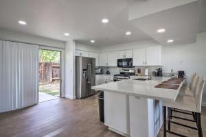 a kitchen with white cabinets and a large kitchen island at Central Bakersfield Townhome with Private Patio in Bakersfield