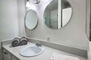 a bathroom with a sink and two mirrors at Central Bakersfield Townhome with Private Patio in Bakersfield +24 photos
