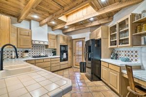 une cuisine avec des armoires en bois et un réfrigérateur noir dans l'établissement Las Cruces Home La Casa Blanca with Courtyard, à Las Cruces