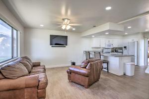 a living room with a couch and a kitchen at Comfy Bakersfield Townhome - Fire Pit and Patio in Bakersfield