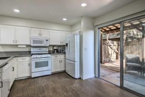 a kitchen with white appliances and a sliding glass door at Comfy Bakersfield Townhome - Fire Pit and Patio in Bakersfield
