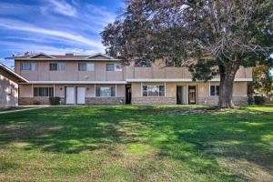 una casa grande con un árbol en el patio en Comfy Bakersfield Townhome - Fire Pit and Patio, en Bakersfield