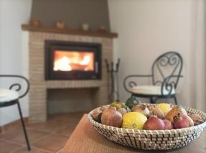 a basket of fruit sitting on a table with a fireplace at Ca l'Apotecari in Calaceite