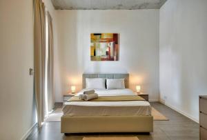 um quarto com uma cama com duas mesas e dois candeeiros em VALLETTASTAY - HARBOR VIEW GEM -SEA VIEW 2 BED APT em Valletta