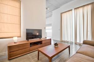 uma sala de estar com uma televisão e uma mesa de centro em VALLETTASTAY - HARBOR VIEW GEM -SEA VIEW 2 BED APT em Valletta