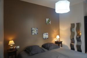 ル・アーヴルにあるLes Gîtes du Monde , Appartements 2 chambres- 4 lits simples modulables en lits doublesのベッドルーム1室(壁に3枚の写真が飾られたベッド1台付)