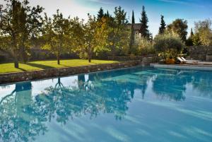 uma piscina com água azul num quintal em Fattoria Casamora - Villa La Leccina em Pian di Scò