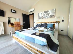 a large bedroom with a large bed with blue sheets at TRA CIELO E LAGO - Gerale H&B (CIR017067-CIM-00420) in Desenzano del Garda +24 photos