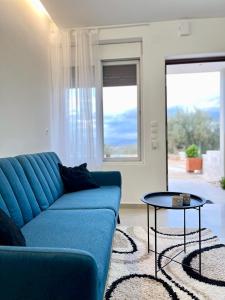 sala de estar con sofá azul y mesa en ενtreé guest house near Palamidi Castle, en Nauplia