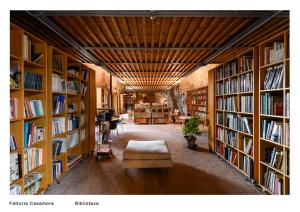 een bibliotheek met boekenplanken en een bank bij Fattoria Casamora - Villa Le Magnolie in Pian di Scò