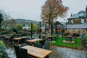 an outdoor seating area with tables and chairs at Grouse & Claret, Matlock by Marston's Inns in Matlock