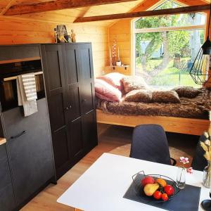 Cette chambre comprend un lit et une table avec un bol de fruits. dans l'établissement Tiny House Flensburg Luv, à Hornholz