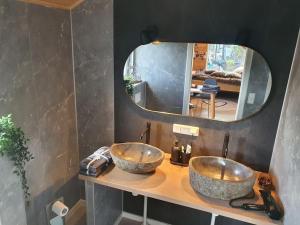 a bathroom with two sinks on a counter with a mirror at Tiny House Flensburg Luv in Jarplund +5 photos