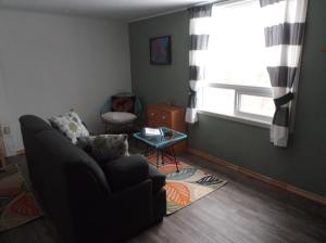 ein Wohnzimmer mit einem Sofa und einem Fenster in der Unterkunft Bed and Breakfast Comfy & Cozy in Huntsville