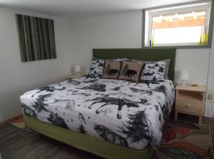 1 dormitorio con 1 cama con edredón blanco y negro en Bed and Breakfast Comfy & Cozy, en Huntsville