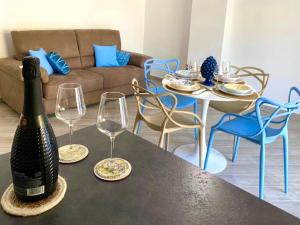 a bottle of wine sitting on a table with two wine glasses at Civuleva! Casa vacanza Capo d Orlando in Capo dʼOrlando +30 photos