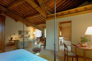 a bedroom with a bed and a living room at Fattoria Casamora - Suites in Pian di Sc&ograve;