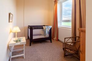um quarto com uma cama, uma cadeira e uma janela em No 2 Sparham Hall em Necton