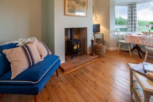 a living room with a blue couch and a fireplace at No 2 Sparham Hall in Necton