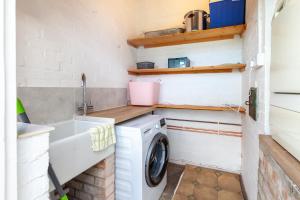 uma pequena cozinha com uma máquina de lavar roupa e um lavatório em No 2 Sparham Hall em Necton