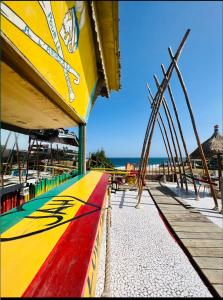 - une planche de surf colorée sur une plage donnant sur l'océan dans l'établissement Maison du Bonheur, à Dakar