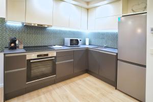 a kitchen with stainless steel appliances and white cabinets at Sweet Stay Castle Apartment in Ljubljana