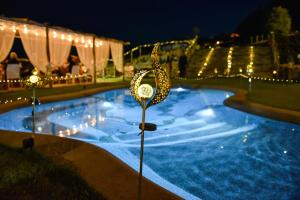a swimming pool with lights in the yard at night at Essenziale in Castell’Anselmo