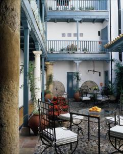 un patio con sillas y mesas en un edificio en Hospes Las Casas Del Rey De Baeza, en Sevilla