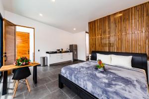 a bedroom with a bed and a desk and a kitchen at House of Nomad - Adults only in Tamarindo