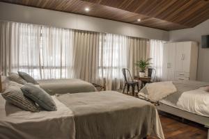 a bedroom with two beds and a table and a window at Casa Reconquista in Mendoza +98 photos