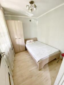 ein kleines Schlafzimmer mit einem Bett und einem Schrank in der Unterkunft Apartment on Maylin 30 12 in Turksib