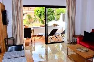 ein Wohnzimmer mit einem roten Sofa und einem Tisch in der Unterkunft Comfortable home with garden view in San Miguel de Abona