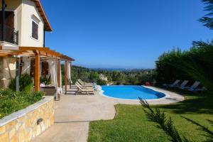 a backyard with a swimming pool and a house at Villa Verde in Pouládes +37 photos
