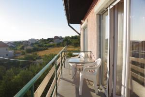 d'un balcon avec une table et des chaises et une vue. dans l'établissement Apartments Opsenica Barbat, à Barbat na Rabu