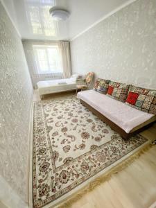 ein Schlafzimmer mit einem Bett und einem Teppich in der Unterkunft Apartment on Maylin 30 12 in Turksib