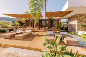 a patio with couches and a pool in a house at Kouros Exclusive Hotel & Suites - Adults Only in Faliraki