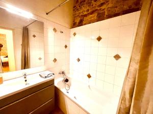 uma casa de banho com uma banheira, um lavatório e um chuveiro em Le MOKA Charmant Appartement au coeur de ville em Nîmes
