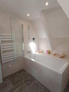 een witte badkamer met een douche en een bad bij Ker Leo in Saint-Cast-le-Guildo