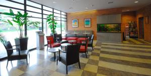 restauracja z czerwonymi krzesłami, stołami i oknami w obiekcie Expo Hotel w Pradze