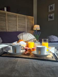 una mesa de desayuno con dos tazas y platos de comida en Domaine de la Baratonne, en La Garde