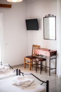Habitación con escritorio, silla y espejo. en Elektra Hotel en Paleros