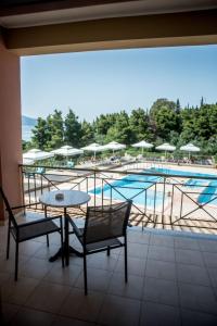 eine Terrasse mit einem Tisch und Stühlen sowie einem Pool in der Unterkunft Elektra Hotel in Palairos