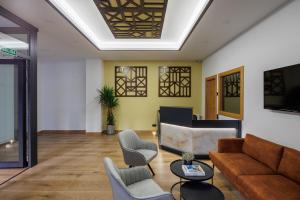 un soggiorno con divano e sedie di Apartamentos Congreso, Parking gratuito a Logroño