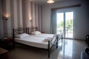 sypialnia z łóżkiem i dużym oknem w obiekcie Elektra Hotel w mieście Paleros