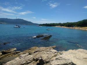 un gran cuerpo de agua con barcos en una playa en Chalés Azuleto - Ilhabela, en Ilhabela