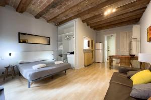 een slaapkamer met een bed en een woonkamer bij ApartEasy - Gracia Apartments in Barcelona