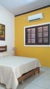 um quarto com uma cama e uma janela com ar condicionado em Chalés Azuleto - Ilhabela em Ilhabela