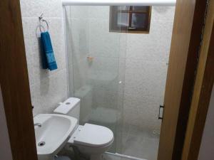 y baño con ducha, aseo y lavamanos. en Chalés Azuleto - Ilhabela, en Ilhabela
